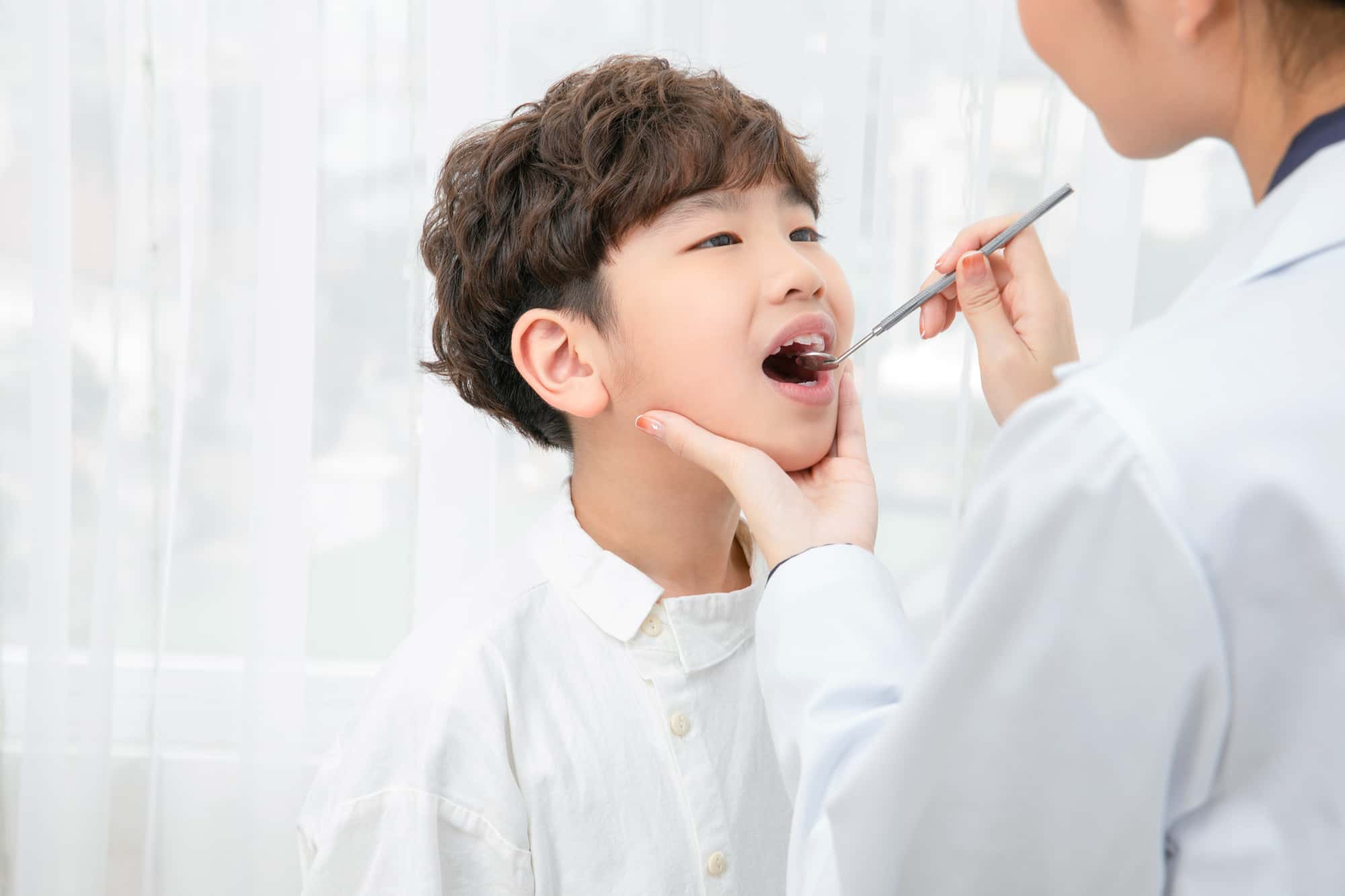 インビザライン・ファーストの治療の為に口内チェックをする男の子