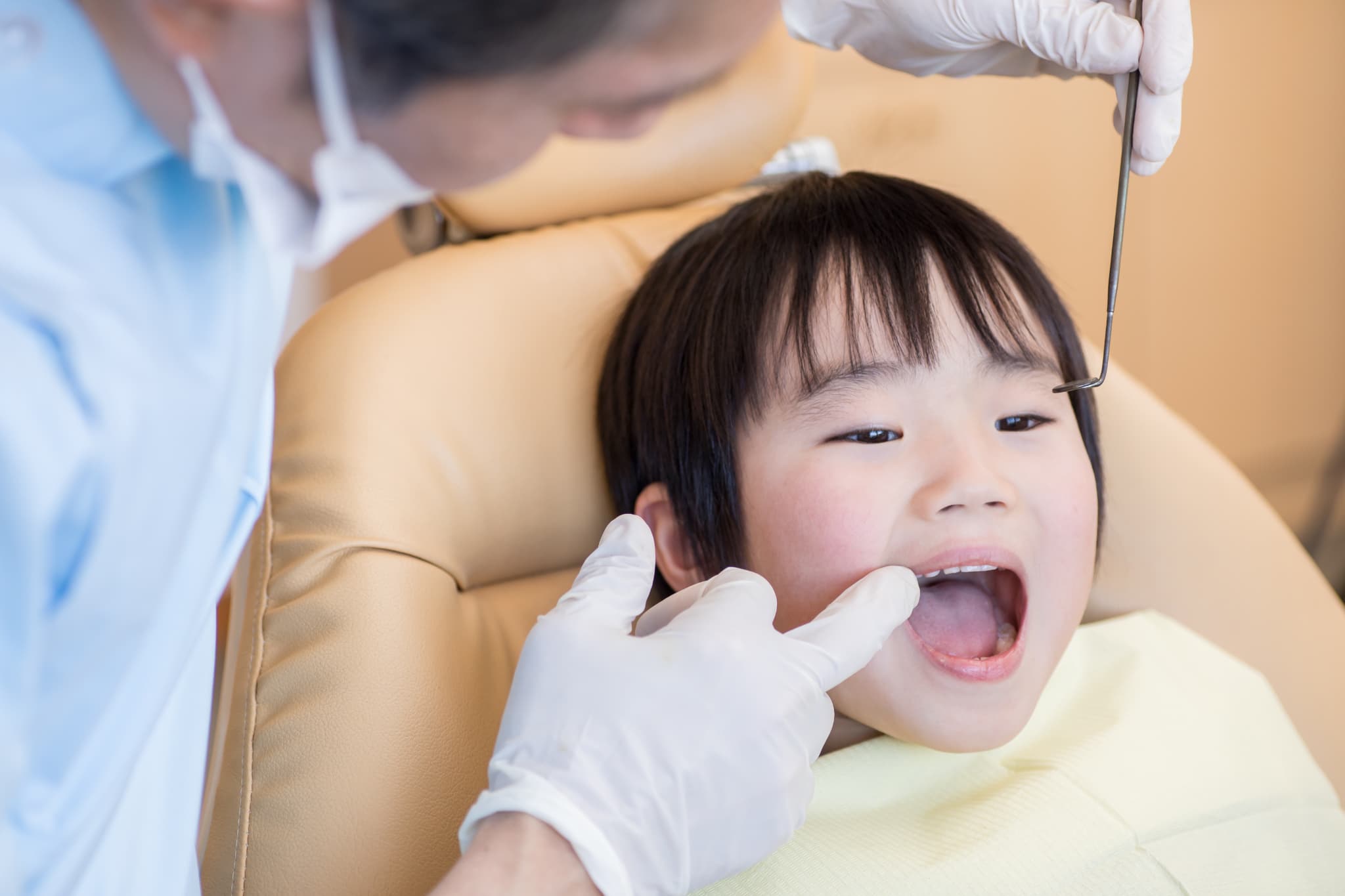 歯科医院で男の子の歯並びを確認する様子