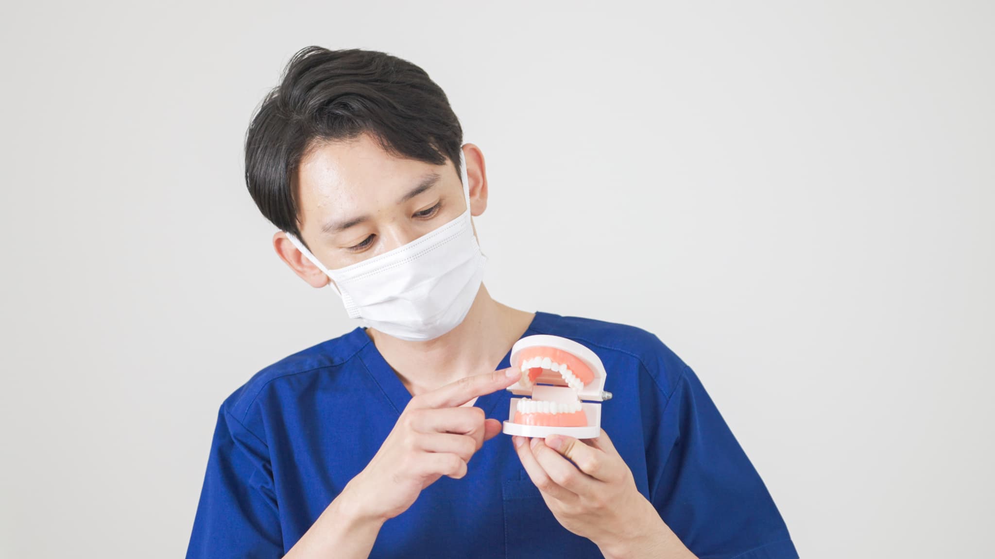 定期検診でチェックする内容を説明する歯科医師