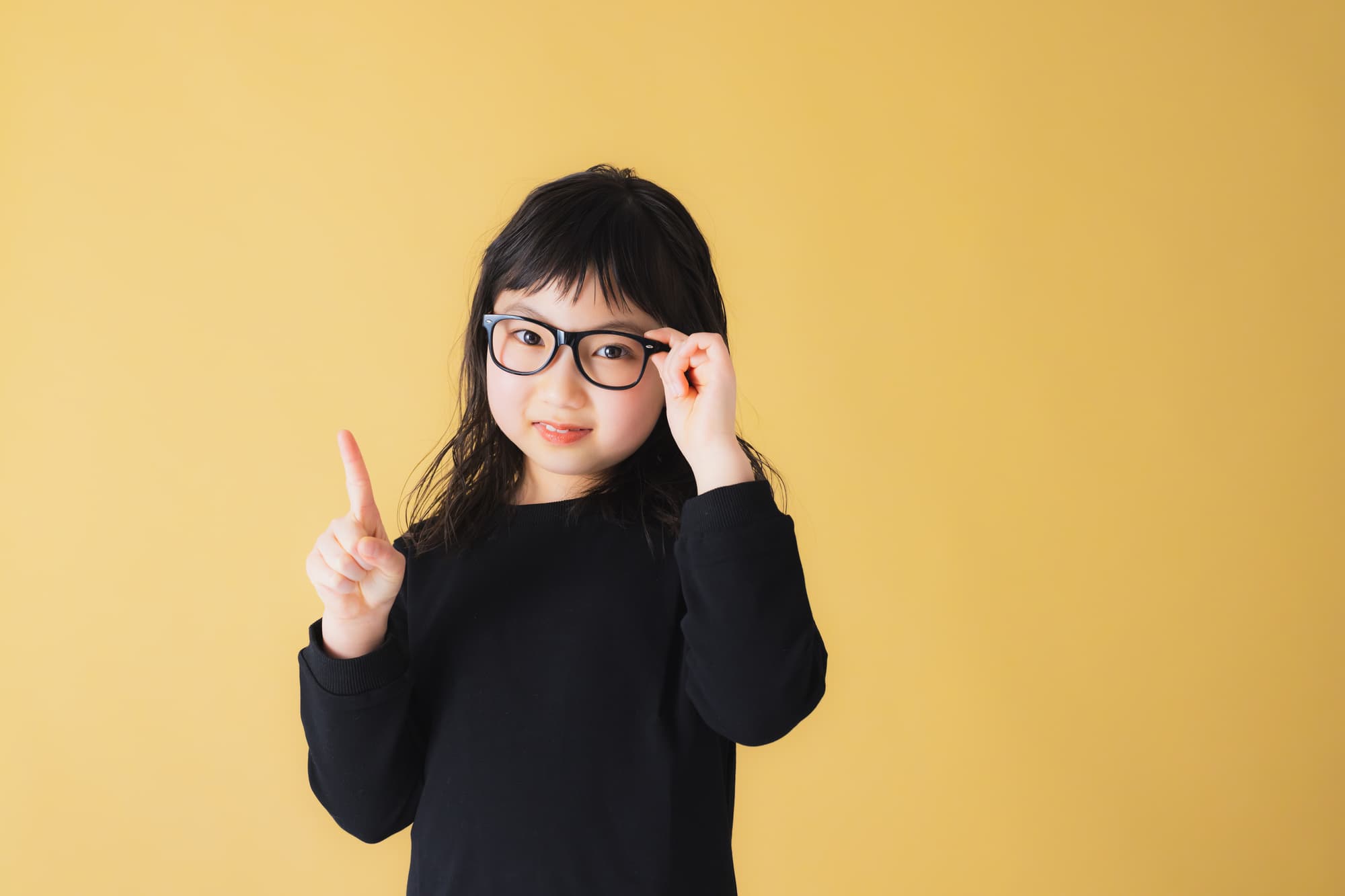 眼鏡をかけ指をさす子ども