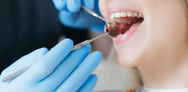 根管治療の流れとして、歯科医師に歯をチェックしてもらっている女性