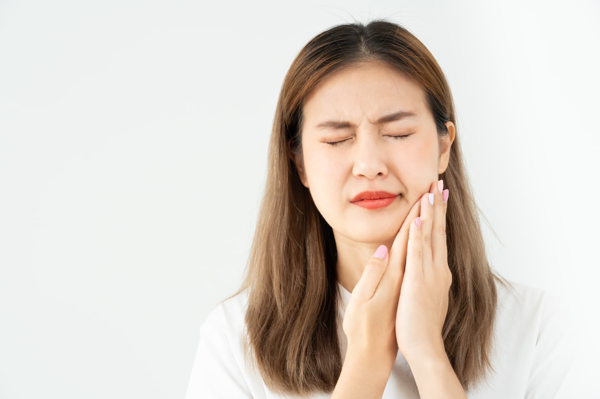 矯正治療中に痛みが出て痛がる女性