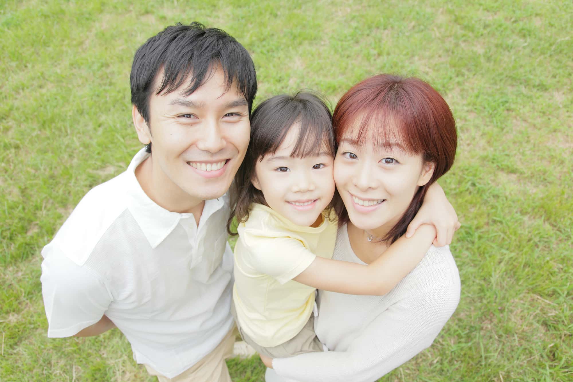 出っ歯を矯正して治った子どもを抱っこした笑顔の母と父