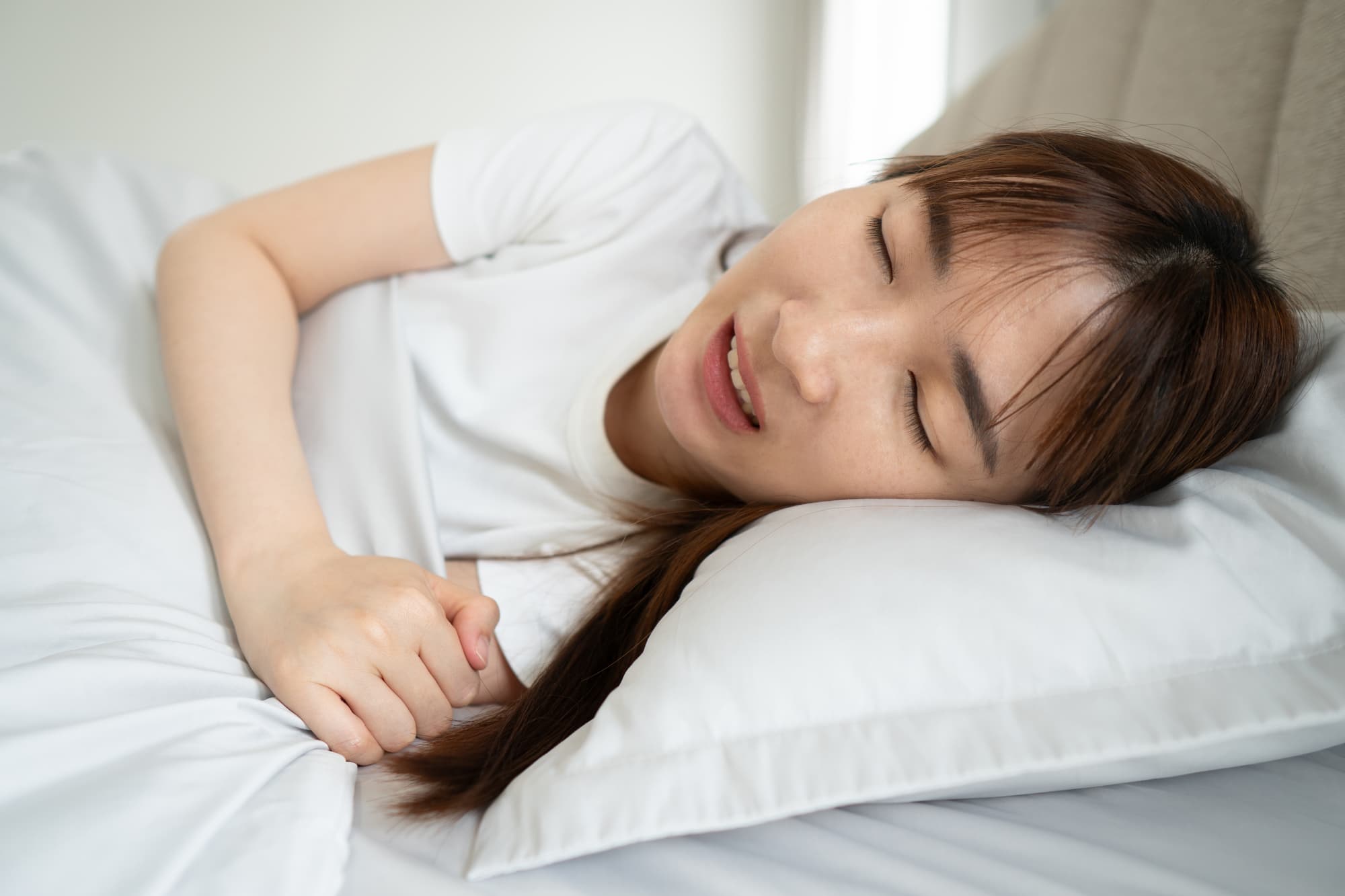 睡眠中に歯ぎしりをする女性